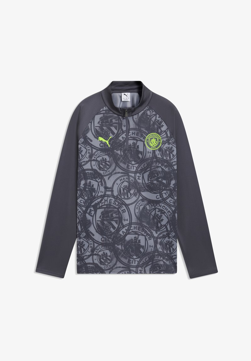 Haut d'entraînement à manches longues de Manchester City en gris foncé avec logos Puma et du club en jaune néon, col à demi-fermeture éclair, et motif répétitif du blason du club.