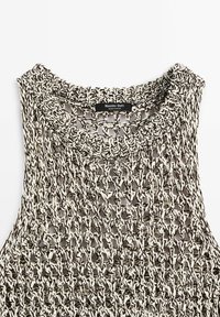 Haut sans manches tricoté noir et blanc avec un col rond et un motif à maille ouverte, étiqueté Massimo Dutti, fabriqué en Espagne.