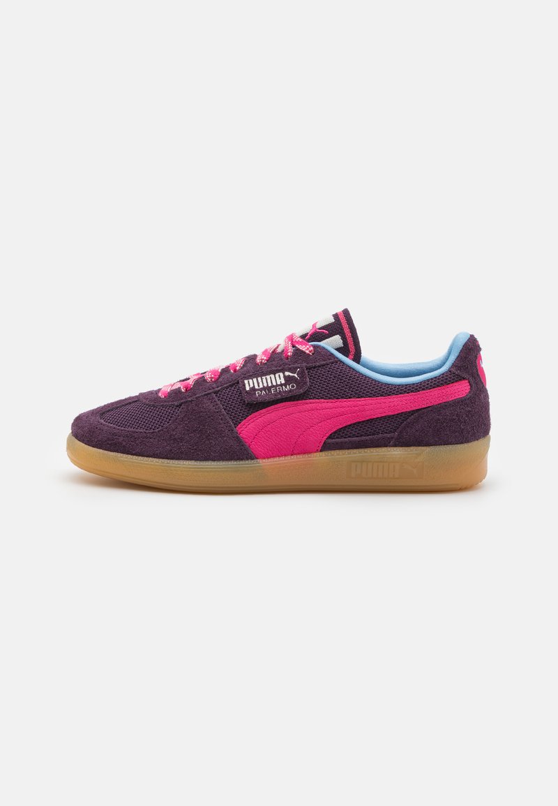 Zapatillas de ante moradas con acentos rosas, paneles de malla y detalles en azul claro. Presenta una suela de goma y cordones rosas. Logotipo de Puma visible.