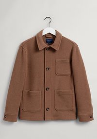 Braune Jacke aus Wollmischung mit Kragen, Frontknopfleiste und zwei großen Fronttaschen. Verfügt über ein strukturiertes Gewebe und schwarze Knöpfe.