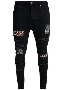 Jeans ajustados negros con desgastes y roturas, con parches de leopardo y paisley. Hechos de mezclilla, tienen un corte slim y un diseño clásico de cinco bolsillos.