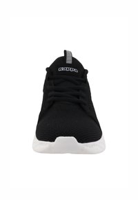 La chaussure de sport noire présente une tige en mesh respirant, des lacets plats et une semelle blanche texturée. Le logo "Kappa" est visible sur la languette ainsi qu'une tirette rayée.