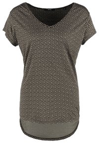 Blouse pour femme à manches courtes, noire et blanche à motifs, col en V et ourlet arrondi.