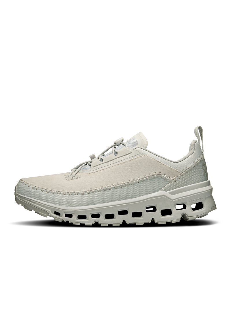 Light gray athletic shoe with a textured upper, lace closure, and pronounced sole featuring ventilation holes for breathability.