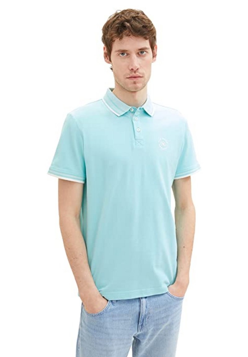 Polo bleu clair en tissu respirant, avec une patte de boutonnage à trois boutons, un logo brodé et des bordures blanches contrastées sur le col et les manches.