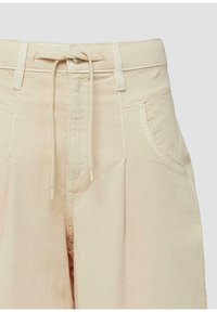 Pantalon taille haute beige avec passants pour ceinture, poches avant, fermeture à boutons et cordon de serrage noué à la taille.