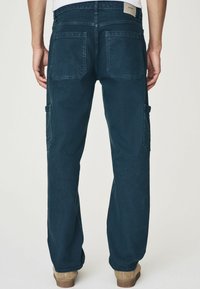 Donkerblauwe cargobroek van denim, met twee achterzakken en een zijzak, met een recht model en opgerolde pijpen.