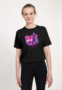 Sort bomulds T-shirt med et levende grafisk print i pink og lilla med teksten "WILD Style" og en illustreret figur.