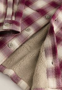Flanellen overhemd met een paars-crèmekleurig ruitpatroon, een zachte beige fleece voering, plastic knoppen en een gestructureerde weefstructuur.