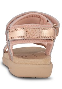 Roséguld justerbara sandaletter med en mjuk beige fotbädd, överdel i texturerad tyg och en robust gummisula för bättre grepp.