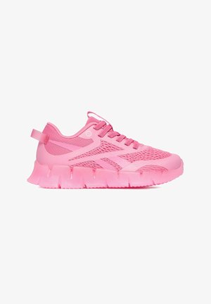 Jaskraworóżowy sportowy sneaker z panelami z siateczki, grubą segmentowaną podeszwą, sznurowaniem oraz pętelką z tyłu, pokazany z profilu.