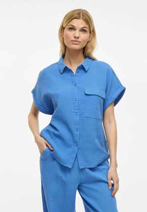 Light blue short-sleeve shirt made of textured fabric, featuring a collared neckline and a single chest pocket.