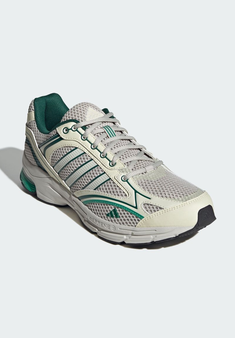 Hellgraue Laufenschuhe mit Mesh-Obermaterial, grünen Akzenten und drei weißen Streifen. Verfügt über einen gepolsterten Schaft und eine schwarze Gummisohle.