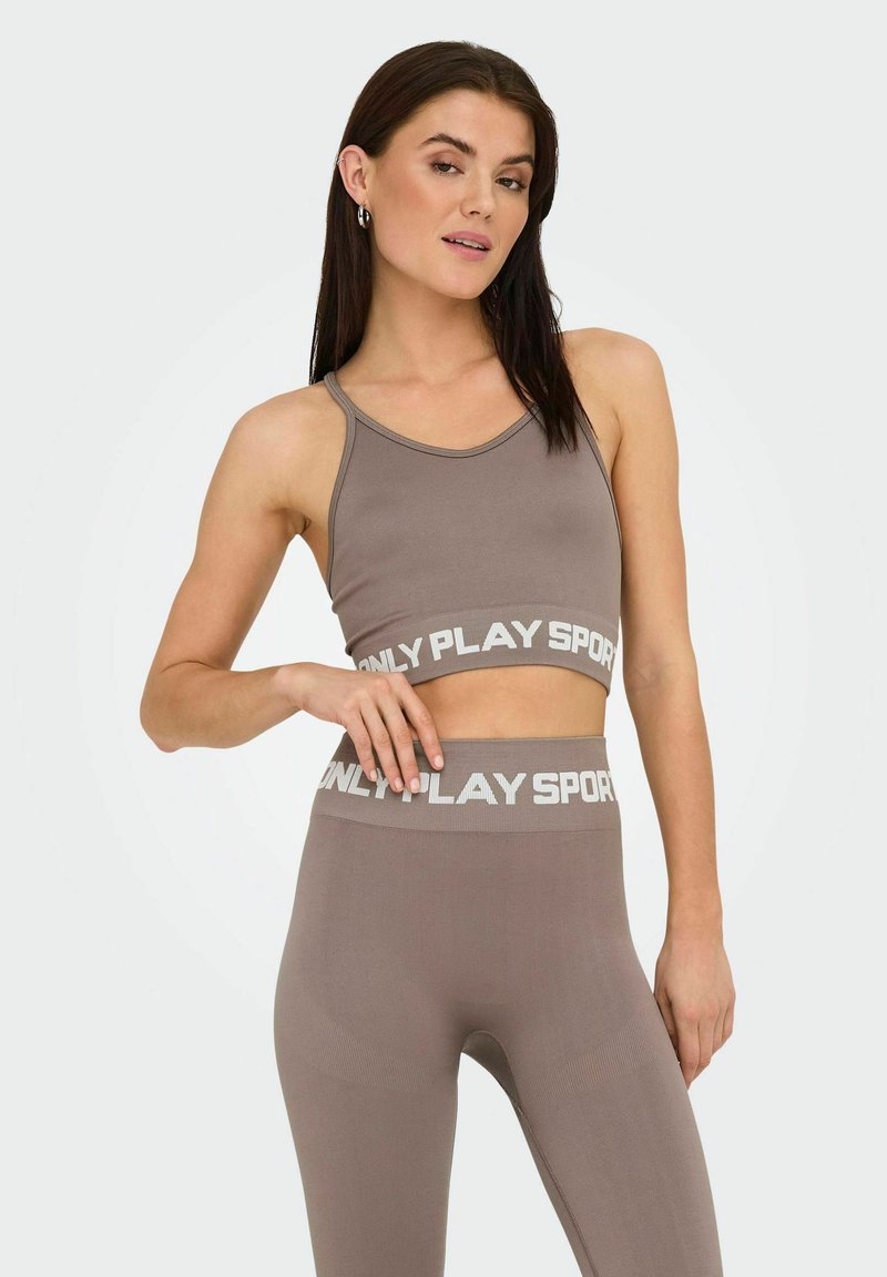 Brązowy zestaw sportowego biustonosza i legginsów z szerokim paskiem "ONLY PLAY SPORTS". Gładka textura, dopasowany krój i minimalistyczny styl.