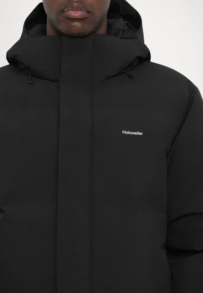 Black puffer jacket with a high collar and drawstring hood. Features a minimalistic logo in white on the chest and sleek, smooth texture.