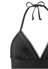 Zwarte halterbikini-top met gegolfde rand, driehoekige cups, textuurmateriaal en verstelbare banden om de nek voor een veilige pasvorm.