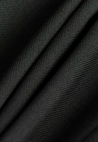 Schwarzer Stoff mit einer strukturierten Webart, die gefaltete Schichten und eine matte Oberfläche zeigt, wobei die glatte Oberfläche und das engmaschige Muster betont werden.