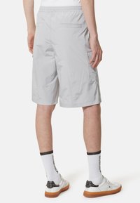 Pantaloni corti grigi chiari in un materiale leggero, dotati di una vita elastica e tasche laterali, con un taglio dritto e una lunghezza fino al ginocchio.