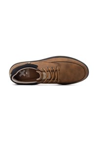 Zapato de cuero marrón con puntera redondeada, acentos negros y seis agujeros para los cordones. Cordones color beige y superficie texturada con una suela de goma plana.