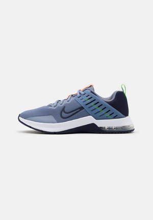 Chaussure de course Nike bleue et marine avec semelle blanche, unité Air Max visible, logo Swoosh noir, languettes de lacets orange et languette de talon verte.