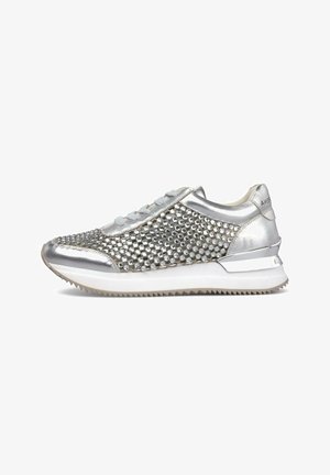 Zapatilla baja plateada con tachuelas metálicas, suela blanca, diseño con cordones y suela exterior texturizada para tracción, mostrada de perfil.