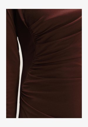 Tmavě hnědá látka s hladkou texturou, zdobená na straně nabíranými detaily a jemným skládáním v oblasti hrudníku.