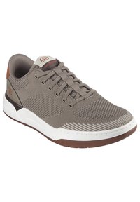 Zapatilla deportiva gris hecha de material de malla, con un diseño de cordones, una media suela blanca y una suela exterior de goma marrón con detalles de cuero.