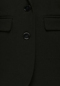 Black blazer with two visible buttons and two front pockets. Made of smooth fabric with a tailored fit. Buttons feature a shiny finish.