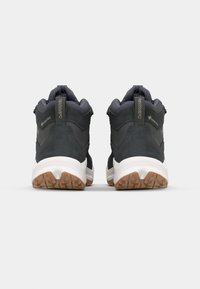 Scarpe da trekking in suede nero e tessuto con accenti grigi, dotate di un'intersuola bianca e suola in gomma. Marchio GORE-TEX sul retro.