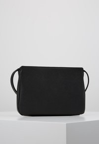 Černá obdélníková kabelka s texturovaným povrchem, která má dvě boční ucha a minimalistický design. Hladký povrch bez viditelného kování.