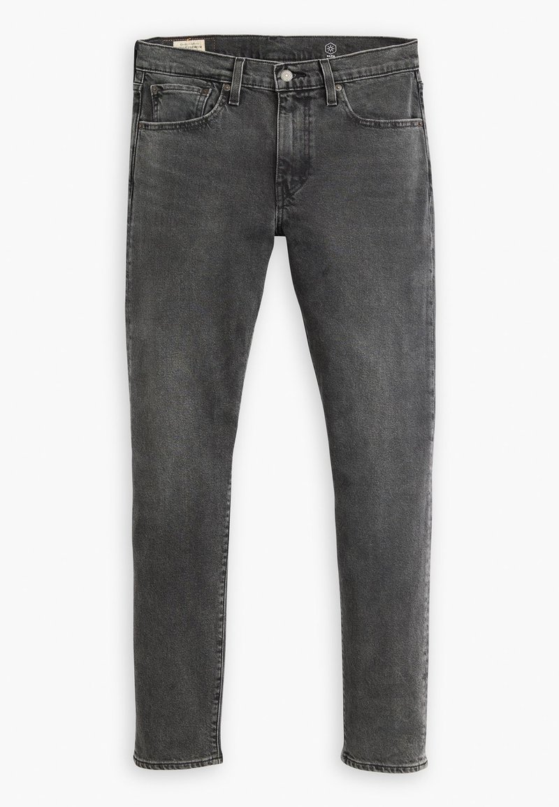 Jean en denim slim fit de couleur noir délavé avec une texture lisse. Dispose de cinq poches, de passants de ceinture et de coutures contrastées.