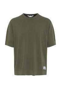 Olivově zelené tričko s krátkým rukávem, vyrobené z jemné tkaniny, s kulatým výstřihem a malou štítkovou detailní aplikací na dolním levém rohu.