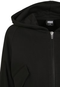 Felpa con cappuccio nera con zip frontale, tessuto morbido, dettagli a costine sui polsini e tasca inclinata sul lato sinistro.
