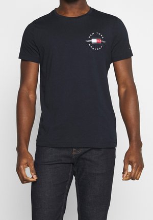 Navy blue cotton t-shirt with short sleeves, round neckline, and front logo featuring red, white, and blue accents in a circular design.