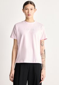 Ανοιχτό ροζ βαμβακερό t-shirt με κοντά μανίκια, με κεντημένο το "Calvin Klein" σε λευκό στην περιοχή του στήθους. Κλασικός στρογγυλός λαιμός και άνετη ε�φαρμογή.