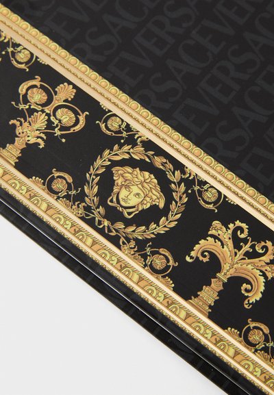 Tessuto nero con un disegno barocco dorato con motivi intricati, inclusa una testa di Medusa e accenti ornamentali, incorniciati da un delicato motivo con logo.