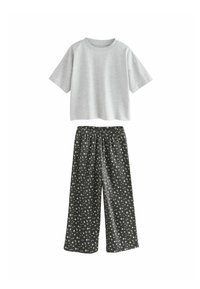 Graues Kurzarm-T-Shirt, kombiniert mit schwarzen weit geschnittenen Hosen mit einem weißen Blumenmuster und elastischem Bund. Baumwollmischgewebe.