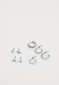 Set of silver earrings including studs and hoops with varied designs: round, hexagonal, twisted, and embellished with blue and clear stones.