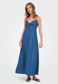 Denim maxi haljina, plava, sa spaghetti naramenicama, otvorom na prednjem dijelu i mašnom na prsima. Mekana tekstura, lepršavi silueta, dužina do anklai.