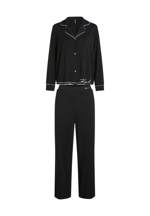 Melna pidžamu komplekts, kas izgatavots no mīksta auduma, ar pogu kreklu ar baltu apdari un platām biksēm, abas ar logotipa akcentiem.