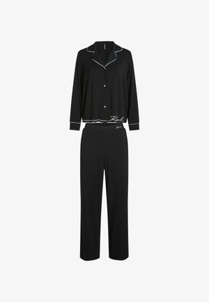 Must mustra mustri, pehmeast kangast, koosneb nööpidega särgist valge äärisega ja laiade säärega pükstest, mõlemal on logo aktsendid.