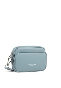 Borsa a tracolla in pelle azzurro chiaro con due scomparti con zip, hardware in argento e logo del marchio in rilievo sulla parte frontale.