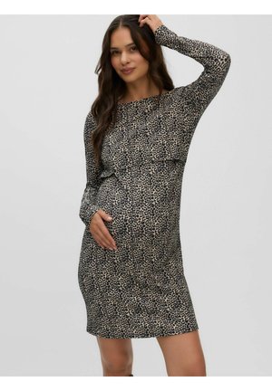 Femme enceinte portant une robe à manches longues imprimée léopard, touchant son ventre d'une main et tenant ses cheveux de l'autre.