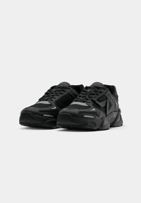 Pair of black athletic sneakers with lace-up design and reflective accents, positioned side by side on a white background.
