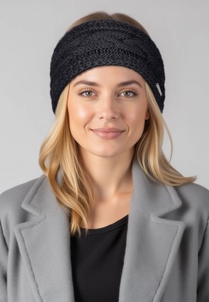 Czarna dziergana opaska na głowę z plecionym wzorem, wykonana z miękkiego materiału. Noszona przez osobę o długich blond włosach, w połączeniu z szarym płaszczem.