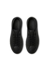 Baskets en cuir noir avec une texture lisse, un design à lacets, un col rembourré et un logo en relief sur la semelle intérieure. Bout rond et semelle plate.