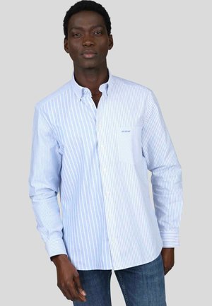 Chemise à boutons, présentant des rayures verticales bleu clair et blanches, fabriquée en coton. Comprend une poche poitrine avec un logo discret.