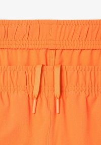 Costumi da bagno arancioni brillanti con cintura elasticizzata e cordino, caratterizzati da una trama liscia e dettagli cuciti lungo il bordo superiore.