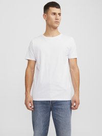 Hvid bomulds-T-shirt med rund hals, korte ærmer og almindelig pasform, parret med lyseblå denimjeans. Enkel design, ingen mønstre.