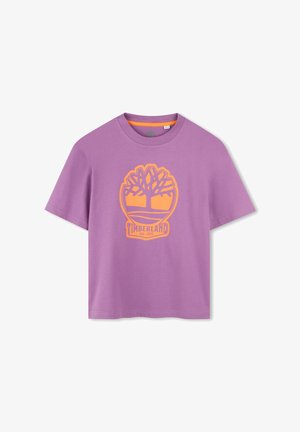 T-shirt in cotone viola con collo rotondo e maniche corte. Presenta un logo ad albero Timberland arancione al centro. Texture liscia.
